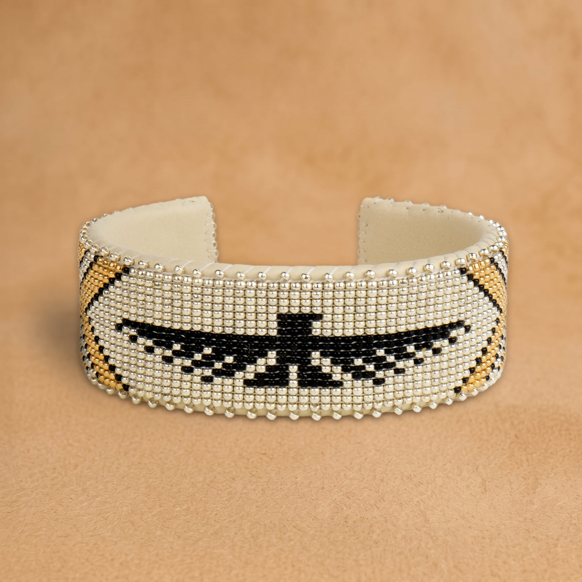 Tallulah Large beaded cuff, silver with a black thunderbird and gold chevrons, handloomed by Navajo artisans in New Mexico